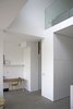 The double-height space encourages social interaction between the ground-floor living space and the lower-ground floor dining space. Photo 3 of Vertical Intersect modern home