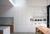 Modern home with Storage Room. The open-plan kitchen and dining space is punctuated by a double-height space, which loosely divides the two zones of use. Photo of Vertical Intersect