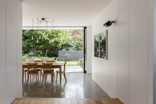 Kauri flooring to the raised living area delineates the living space, while the kitchen and dining spaces are defined by a diamond-ground concrete floor, lowered to be level with the timber decking to the adjacent courtyards.