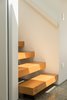 Modern home with Staircase, Wood Railing, and Wood Tread. The form of the top-lit, kauri-clad, open-riser staircase references the drawn appearance of a staircase, and recalls the Stack works of the American artist Donald Judd. Photo 6 of Case Study Villa