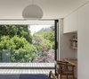Modern home with Bedroom, Medium Hardwood Floor, Ceiling Lighting, Bed, Chair, Shelves, Wardrobe, and Storage. The summit of Maungawhau (Mt Eden) can be seen from the master bedroom and the timber-decked terrace that occupies part of the ground-floor roof. Photo 9 of Case Study Villa