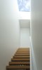 Modern home with Staircase, Wood Tread, and Wood Railing. The form of the top-lit, kauri-clad, open-riser staircase references the drawn appearance of a staircase, and recalls the Stack works of the American artist Donald Judd. Photo 8 of Case Study Villa