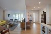 Modern home with Living Room, End Tables, Bench, Chair, Sofa, Coffee Tables, Storage, Wall Lighting, Light Hardwood Floor, Recessed Lighting, Ceiling Lighting, Bookcase, and Console Tables. Front entry and living area. Photo of Gallery Residence