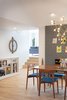 Modern home with Dining Room, Light Hardwood Floor, Pendant Lighting, Shelves, Ceiling Lighting, Standard Layout Fireplace, Storage, Chair, and Table. Steps up to additional living area. Photo 8 of Gallery Residence