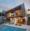The “hanging” porch and open den areas of this modern Los Angeles home are integrated into the outdoor space, allowing the homeowners to enjoy the California weather. The exterior wood siding is just one of the many stunning architectural elements. Photo of Los Angeles Residence modern home