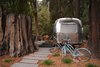 Modern home with Exterior, Metal Siding Material, Curved RoofLine, Airstream Building Type, and Metal Roof Material. A thousand-year-old redwood stump abuts an Airstream suite. Photo 5 of AutoCamp Russian River