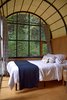 Modern home with Bedroom, Night Stands, Bed, and Medium Hardwood Floor. The curved ceiling of the accessible suite amplifies the spacious feel imparted by the glass facade. Custom curtains, blown glass fixtures, Douglas fir cabinetry with custom steel handles, and a marble-tiled bathroom are just some of the components in this elegant hut. Photo 8 of AutoCamp Russian River