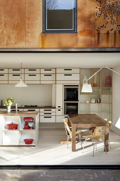 Birch ply cabinets with white melamine facings, walnut worktops, and integrated Siemens appliances create an airy workspace.