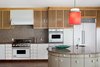 Oversized knobs add a whimsical touch to the kitchen, where a pendant designed by Johanna Grawunder—who worked with Sottsass in Milan—hangs over the circular island. White Viking appliances are integrated with the cabinetry. Photo 3 of The Kelley Residence modern home