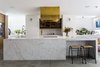 Modern home with Kitchen, Cooktops, Marble Counter, Recessed Lighting, Wall Oven, Wall Lighting, Wood Cabinet, Undermount Sink, Concrete Floor, Brick Backsplashe, and Beverage Center. Brass finishings and an eye-catching range hood contrast with cool Carrara marble. Photo 6 of Clerkenwell Cooperage