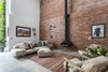 Modern home with Living Room, Concrete Floor, Chair, Floor Lighting, Wall Lighting, Wood Burning Fireplace, Rug Floor, Ottomans, Sofa, and Hanging Fireplace. Formerly the site of a French polishing company in the 20th century, this building in Clerkenwell, London, was converted by Chris Dyson Architects in 2015 into a residence with an expanded basement and triple-height living space that allows a dramatic feature staircase to take center stage. Photo of Clerkenwell Cooperage