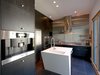 Modern home with Kitchen, Recessed Lighting, Refrigerator, Wall Oven, and Cooktops. The kitchen boasts Forest Stewardship Council-certified bamboo cabinets and stainless steel and concrete countertops. The appliances are by Miele, Leibherr, and GE. Bi-fold glass doors connect the space to the outdoor dining area. Photo 5 of 534 Twin Bridges Road