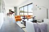 Modern home with Living Room, Concrete Floor, Coffee Tables, Chair, Sofa, and Floor Lighting. A 21-foot sliding glass pocket door opens up the living room to the outdoors, and the southern-facing opening captures winter sun. Throughout the home, windows and doors surpass Energy Star standards. The walls are made from 40% recycled material, and finished in non-VOC paint. Photo 4 of 534 Twin Bridges Road