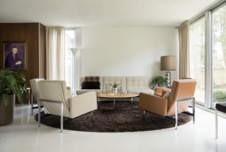 A Knoll Parallel Bar Sofa, Lounge Chairs, and Coffee Table outfit the living room along with a Nessen Studios Torchiere Floor Lamp.