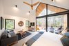 Modern home with Living Room, Sofa, Coffee Tables, Gas Burning Fireplace, Porcelain Tile Floor, Chair, and Ceiling Lighting. Living area with 14 ft ceilings Photo 5 of Kūono at Volcano