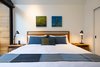 Modern home with Bedroom, Porcelain Tile Floor, Bed, Table Lighting, and Night Stands. Sleeping space with original local art Photo 7 of Kūono at Volcano
