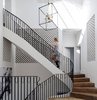 The stair atrium was achieved by infilling a courtyard. The atrium links the lower ground floor living spaces to the first floor bedrooms and the attic level. Veiled behind the terracotta half pipe screens is the hallway running between the bedrooms. Photo 18 of Twin Peaks modern home