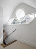 This unusual window was inserted into the pre-existing shape of the gable and a generous attic room was reclaimed from the vast roof space. Photo 9 of Twin Peaks modern home