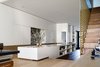 The living room is on a split level, the kitchen bench straddles across the two levels. On the far right, behind the stair there is a dining table. Hidden behind the kitchen cupboard return is the front door.
© Justin Alexander
Photo 12 of Bougainvillea Row House modern home