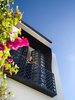 Black and white thrives in the strawberry (hot) pink of the bougainvillea bloom. The film director can throw open the French doors in the early morning, step out onto the balcony and call out his daily instructions to the passing birds and bees on the flowers.
© Justin Alexander
Photo 3 of Bougainvillea Row House modern home
