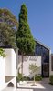On the opposite side of the courtyard, an old garage has been rebuilt and one can still see the raked garage roof shape at the bottom of the attic studio that was added over the garage. Woollahra Council was very supportive of this project and provided an unconditional approval in record time.
© Justin Alexander Photo 6 of Bougainvillea Row House modern home