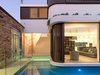 Appearing as a floating houseboat, the two story new building is surrounded by water. The verandah/carport is also new but detailed with traditional exposed rafters and ceiling lining boards, to complete the original verandah.
© Justin Alexander Photo of The Pool House modern home