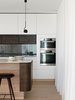 Delicate detailing of the stone makes it float above the stained timber body of the island. This emulates the cantilevered first floor additions outside.
© Justin Alexander
Photo 19 of The Pool House modern home