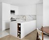 Modern home with Kitchen, Ceiling Lighting, White Cabinet, Microwave, Refrigerator, Marble Backsplashe, Terrazzo Floor, Marble Counter, and Undermount Sink. Open Kitchen Photo 3 of Chelsea Pied-à-Terre