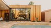 Modern home with Ceiling Lighting, Bed, Concrete Floor, Back Yard, Desert, Small Pools, Tubs, Shower, Salt Water Pools, Tubs, Shower, Stone Patio, Porch, Deck, Exterior, Wood Siding Material, and House Building Type. Master Suite with the glass doors closed Photo 9 of Curves House