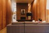 Modern home with Living Room, Sofa, Ceiling Lighting, Concrete Floor, Standard Layout Fireplace, and Wood Burning Fireplace. Living room clad with redwood on both sides with a concrete block fireplace in the center of the double height space Photo 8 of Curves House