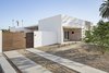 Modern home with Outdoor, Front Yard, Desert, Trees, Shrubs, Pavers Patio, Porch, Deck, and Decomposed Granite Patio, Porch, Deck. Driveway lanes lead to a rolling gate for everyday parking. A 2 car garage is accessed of the alley in the rear. Photo 6 of Sol House