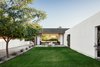 Modern home with Concrete Patio, Porch, Deck, Front Yard, Trees, Shrubs, Ceiling Lighting, Concrete Floor, and Outdoor. The yard doubles as the retention area for the monsoon rainstorms as well as a place for the homeowners to play Photo 4 of Link House