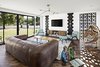 Modern home with Living Room, Bench, Chair, Sofa, Coffee Tables, Recliner, Wall Lighting, Medium Hardwood Floor, and Ceiling Lighting. Family room opens up to the yard Photo 5 of Modern Manor