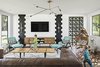 Modern home with Living Room, Chair, Console Tables, Bench, Sofa, Recliner, Coffee Tables, Ceiling Lighting, and Medium Hardwood Floor. Natural light floods the space from both sides Photo 7 of Modern Manor