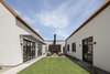 Modern home with Outdoor, Grass, Hardscapes, Back Yard, and Decomposed Granite Patio, Porch, Deck. Central Courtyard anchored by a fireplace with the vaulted great room on the left, and bedroom wing on the right. Photo 9 of Canal House