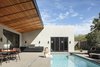 Modern home with Outdoor, Side Yard, Desert, Hardscapes, Raised Planters, Large Patio, Porch, Deck, Trees, Concrete Patio, Porch, Deck, and Small Pools, Tubs, Shower. The 10 foot cantilevered roof and the river rock line in the patio marks the passage of time. In the cooler mornings, like in this photo, the shadow is west of the line and provides and opportunity to embrace the sun. After noon, the shadow crosses the river rock line and starts to shade the area from the harsh afternoon sun, providing some refuge from the direct sun Photo 7 of Weave