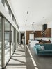 Modern home with Living Room, Concrete Floor, Sectional, Recessed Lighting, and Pendant Lighting. Natural light is filtered through the perforated, corrugated metal patio shade, creating changing patterns on the exposed aggregate concrete floors in the morning Photo 10 of Pleats