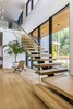 Modern home with Staircase, Wood Tread, and Glass Railing. The floating staircase features glass guardrails and white oak treads to match the hardwood floors. Photo 9 of Wildwood