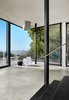 Modern home with Living Room, Chair, Ceiling Lighting, and Concrete Floor. The most dramatic engineering challenge came to the cantilevered corner for an unobstructed view on the northeast corner of the space. The posts hold 3 stories and a roof above, and are made of 6" diameter tube steel. This allows the Fleetwood doors to close to a corner and provides clean views of Downtown San Francisco and the East Bay Hills. Photo 3 of Twin Peaks Escape Pad