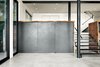 Modern home with Storage Room and Cabinet Storage Type. The "vault" underneath the redwood slab partition in its closed state. The partition is cold formed steel paneling over aluminum honeycomb core doors. Modified pivot hinges by Rixson and a custom recessed track allow the partition to function smoothly and without deflection. Photo 9 of Twin Peaks Escape Pad