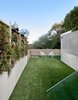 The yard is at the lowest elevation on the property, and was carved out to have a place for the family to play and relax. The turf is by Heavenly Greens. The space features clear heart cedar boards with a reactive stain by Weatherwood Stains. The 30 foot green wall in implemented in segments and features built in drip irrigation. The mirrored solar reflector, which appears to have just dropped out of planetary orbit, grabs southern light and reflects it into the home and exterior spaces. Photo 12 of Twin Peaks Escape Pad modern home