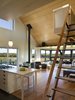 Sliding fabric panels allow the enclosed porch to be used for dining or overflow sleeping. A loft overlooking the main living space and views of the farm serves as office space. Photo of Yum Yum Farm modern home