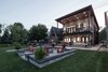 Beach Façade: A paved seating area surrounds a fire pit just beyond the house. Photo 2 of Turkey Point Beach House modern home