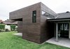 Modern home with Outdoor, Grass, Concrete Patio, Porch, Deck, and Horizontal Fences, Wall. The contemporary addition features dark cedar siding and a flat roof at the existing gable structure and rear patio. Photo 15 of Villa Park Modern