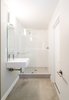 Modern home with Bath Room, Concrete Floor, Ceiling Lighting, and Open Shower. A new compact white bathroom with concrete flooring and open shower is accessed from a new guest bedroom behind the kitchen, as well as from the rear yard. Photo 14 of Villa Park Modern