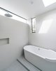 Modern home with Bath Room, Porcelain Tile Floor, Ceiling Lighting, and Open Shower. At the rear of the home, the master suite addition adds a full wet room with skylight, a rain shower and freestanding tub. Photo 12 of Villa Park Modern
