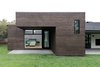 Modern home with Exterior, House Building Type, Shingles Roof Material, Wood Siding Material, and Flat RoofLine. The dark stained cedar-clad cantilever with flat roof juxtaposes the existing traditional details and massing at the rear. Photo 4 of Villa Park Modern