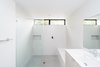 Modern home with Bath Room, Engineered Quartz Counter, Porcelain Tile Floor, Undermount Sink, Open Shower, Ceiling Lighting, and Ceramic Tile Wall. A minimalist secondary bath features a quartz waterfall bench and oversized custom shower. Photo 2 of Villa Park Modern