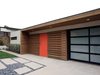 Modern home with Exterior, Shrubs, Front Yard, Swing Door Type, Hardscapes, Grass, Desert, Walkways, Horizontal Fences, Wall, Wood Fences, Wall, Concrete Patio, Porch, Deck, Attached Garage Room Type, and Outdoor. An asymmetrical cedar awning defines the home's entry, while adding texture and warmth at the smooth stucco and glass exterior. Photo 3 of Laguna Niguel Mid-Century