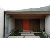 Modern home with Exterior, Swing Door Type, Front Yard, Grass, Walkways, Hardscapes, Horizontal Fences, Wall, Concrete Patio, Porch, Deck, Small Patio, Porch, Deck, Wood Fences, Wall, Stone Patio, Porch, Deck, Attached Garage Room Type, and Outdoor. Ridge line views from the central courtyard highlight the topography of the natural coastal landscape, while cedar, concrete, and low-maintenance plantings enable seamless indoor-outdoor living. Photo 4 of Laguna Niguel Mid-Century